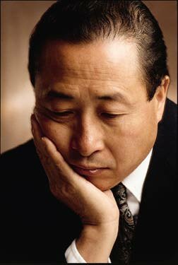 Man with downcast eyes and head resting down on hand